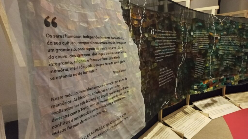 Painéis um ao lado do outro. O primeiro é branco translúcido e os seguintes pretos translúcidos, com textos do espaço "Rio de Memórias"