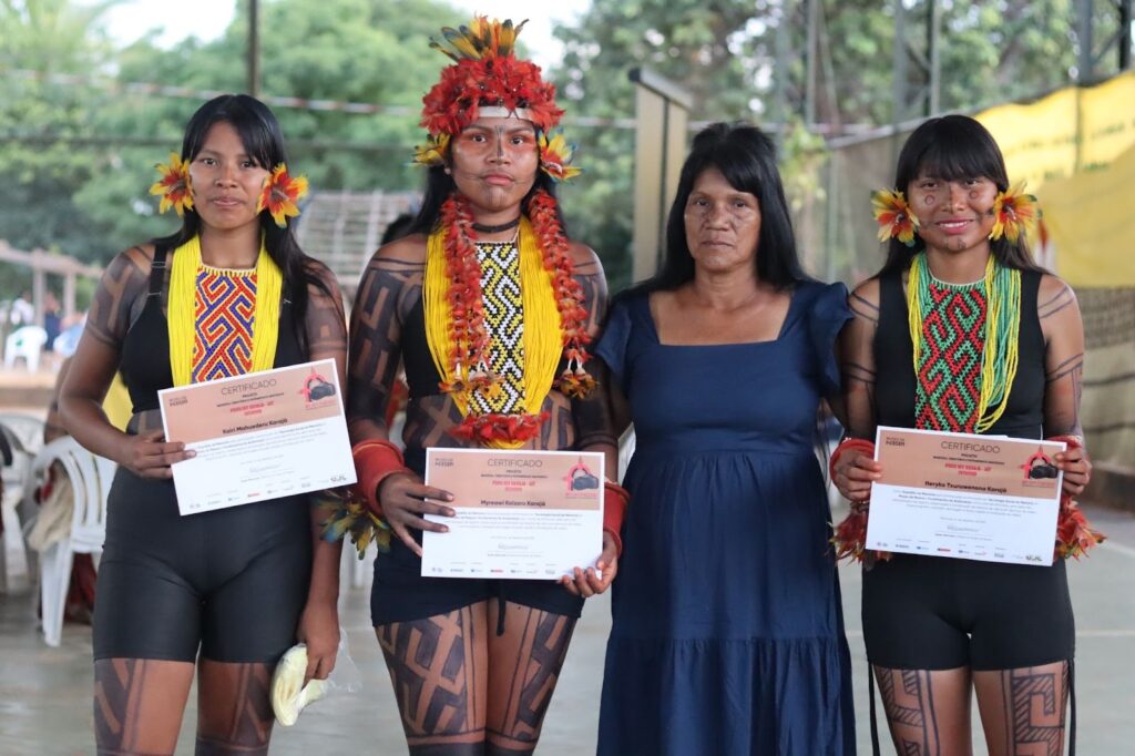 Mulheres indígenas seguram o certificado de conclusão da formação em Tecnologia Social da Memória. 