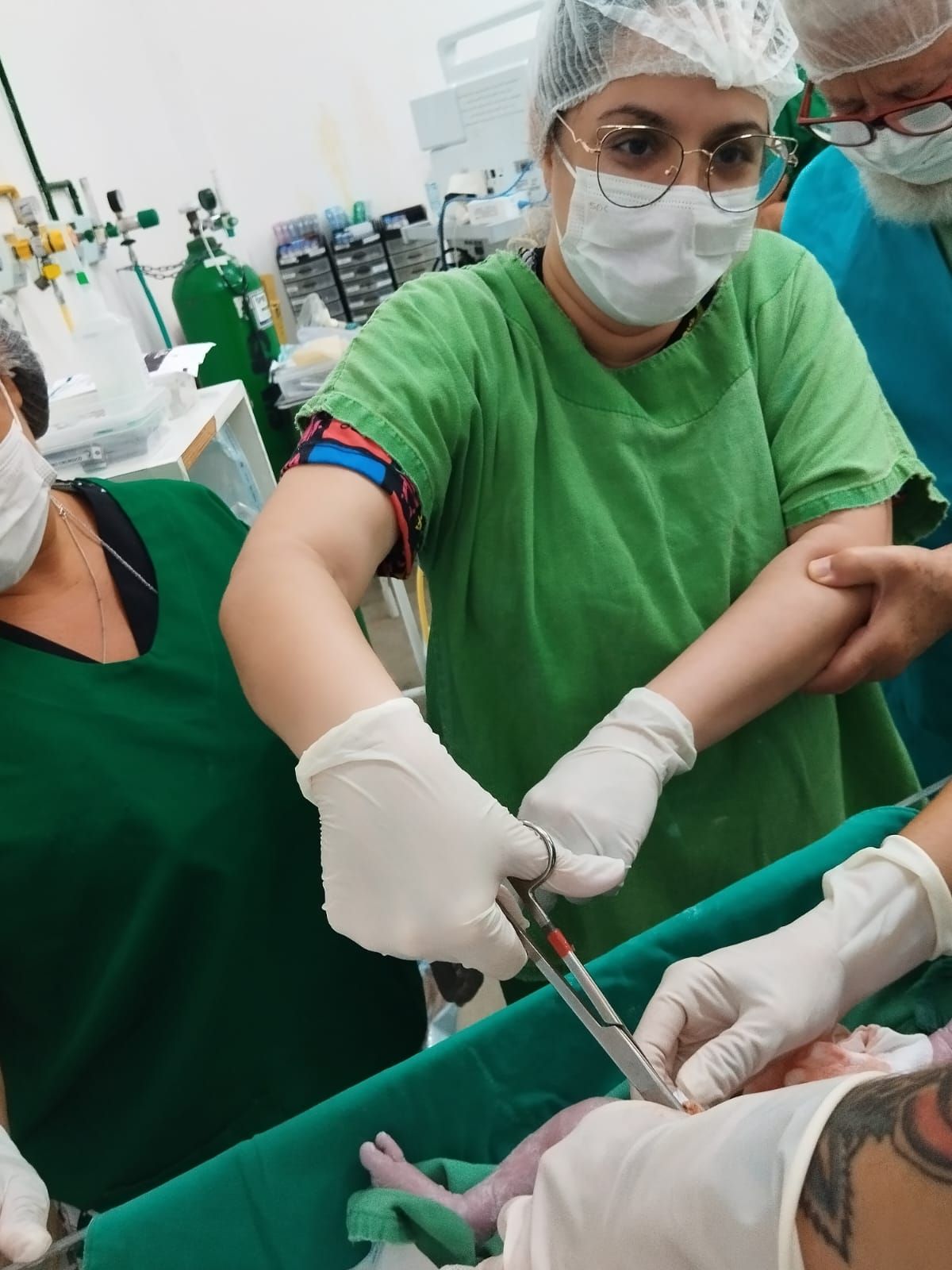 A titia Carol cortando o cordal umiblica da Alaninha e o vô ao lado orando. Oh glória! 