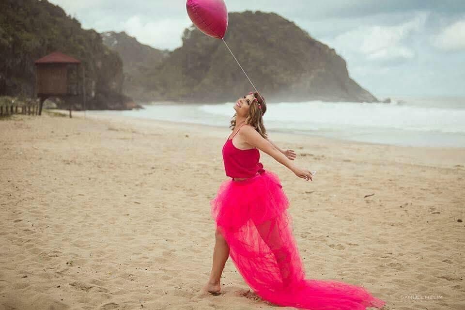 Meu primeiro ensaio para o Outubro Rosa aconteceu na praia do Canto do Morcego, em Itajaí, e marcou muito mais do que fotos bonitas. Depois do câncer de mama, estar ali representava minha vitória, minha força e meu renascimento.
Durante muito tempo, meu corpo carregou cicatrizes e inseguranças, mas naquele dia eu consegui me enxergar novamente como uma mulher forte, bonita e cheia de vida. O rosa simbolizava minha luta, minha coragem e a esperança que nunca perdi.
Entre o mar, o vento e o céu, senti que estava deixando para trás parte da dor e celebrando tudo o que sobrevivi. Aquele ensaio não foi apenas sobre aparência  foi sobre reencontrar a mim mesma e agradecer pela vida.