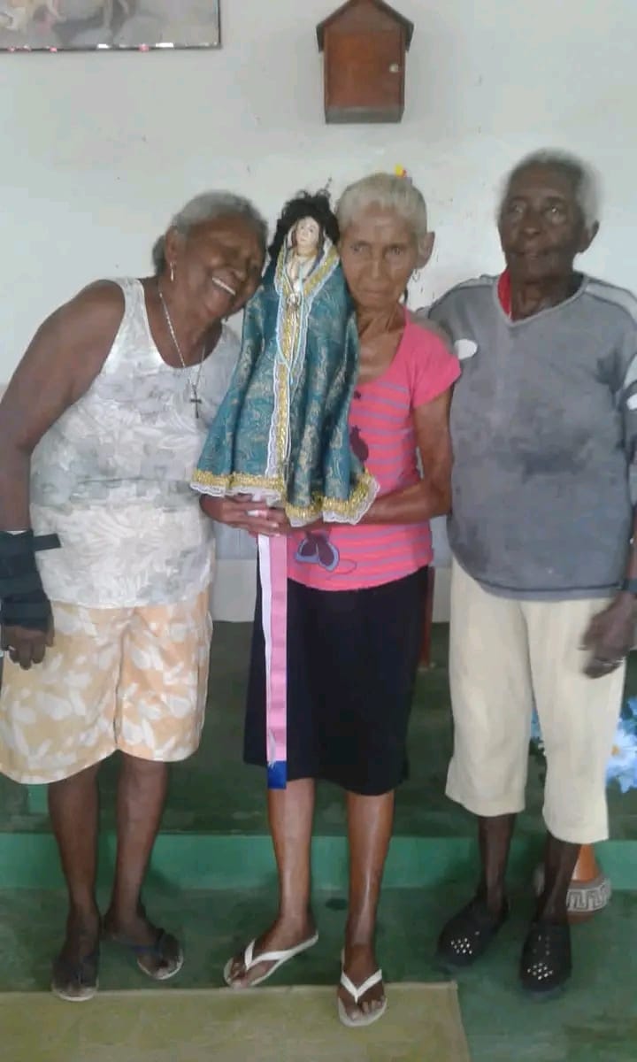 NA IMAGEM DONA DIVINA SORRINDO AO LADO DE DEVOTAS DE NOSSA SENHORA DA CONCEIÇÃO
